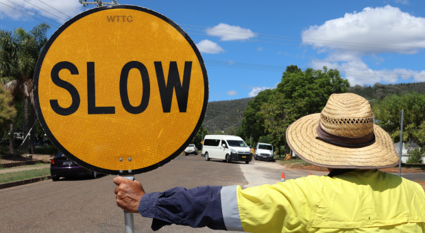 An image of a roadworker holding a slow sign